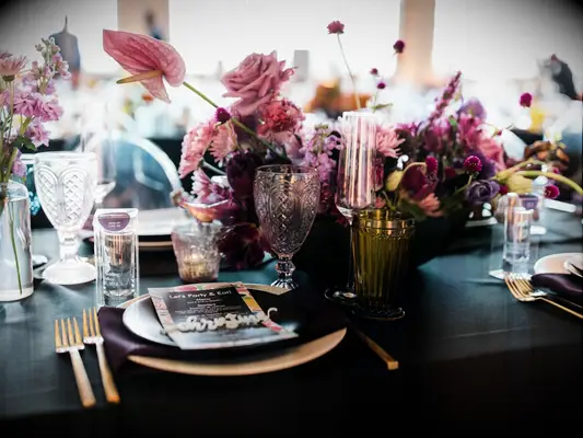 purple fall wedding centerpiece with gold accents and flatware