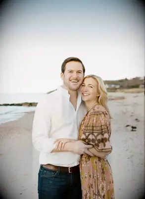 Couple smiles at the camera on a beautiful beach. 