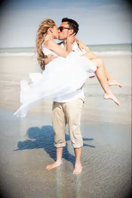 Couple kisses in a romantic moment on the beach. 