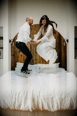 Couple jumping on bed