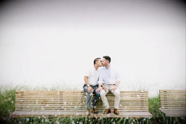 Beachside bench kissing engagement photo