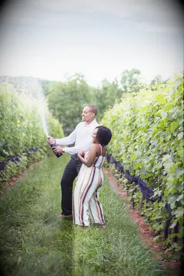 Couple sprays champagne during winery engagement session