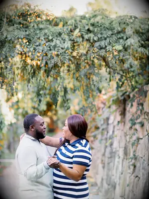 Couple embraces under vines during engagement photo shoot