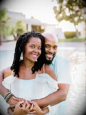 Couple shares hug during beach engagement photo shoot