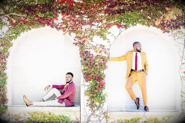Engagement photo with vine-covered wall backdrop