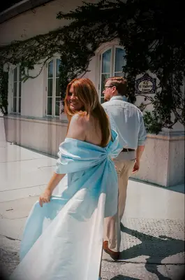 Couple engagement photo walking away from camera and smiling back