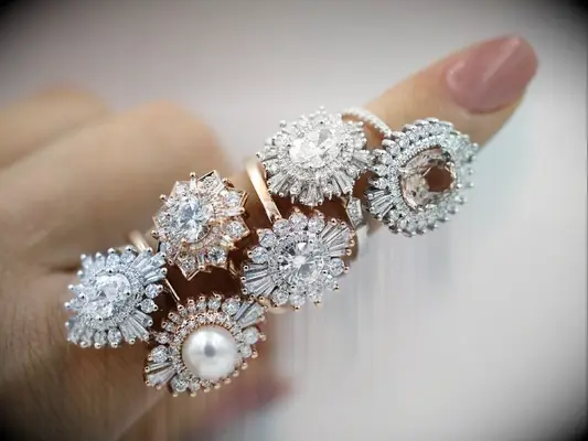 stack of six halo engagement rings on finger