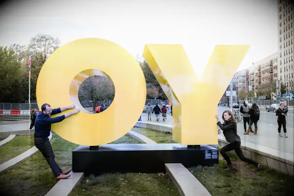 Couple poses with sculpture outside of an art museum. 