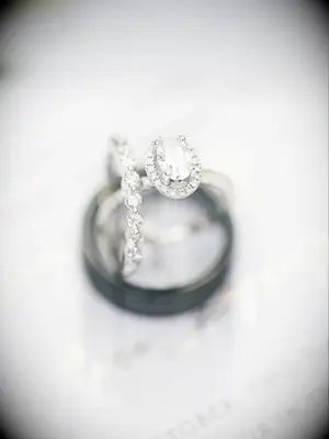 White gold oval-cut engagement ring stacked on two wedding bands