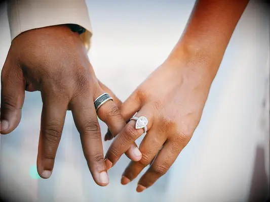 Bride wearing diamond pear-cut engagement ring on wedding day