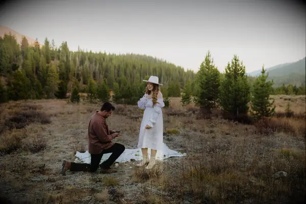 Man proposing to woman in field during fall