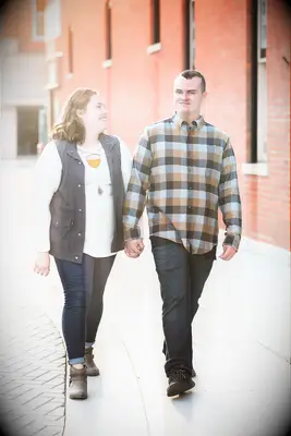 Couple wearing fall outfits holding hands while walking