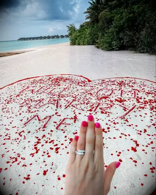 ring selfie in front of engagement proposal spot on the beach