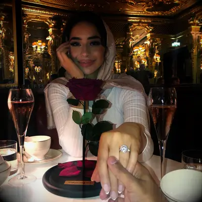 Engagement ring selfie of woman holding out hand at dinner