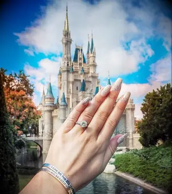 Engagement ring selfie in front of Magic Kingdom at Disney