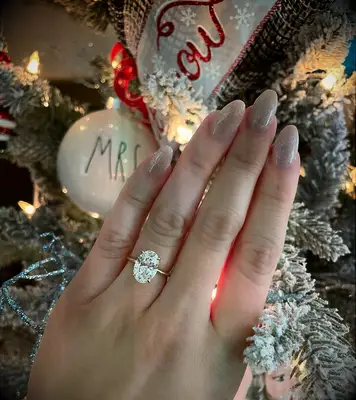 Oval engagement ring photo in front of Christmas Tree