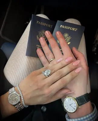 Couple with passports wearing wedding and engagement rings 
