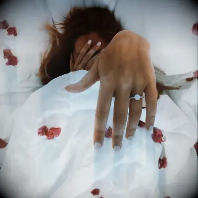 Engagement ring selfie under covers with rose petals