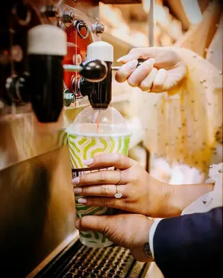 couple taking engagement ring photo at slurpee machine 