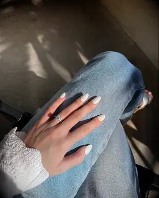 Engagement ring resting on jeans