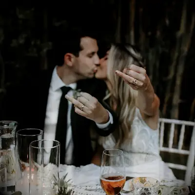 Bride and groom posing for couple engagement ring selfie on wedding day