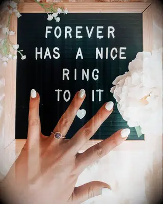 Engagement ring selfie in front of letter board