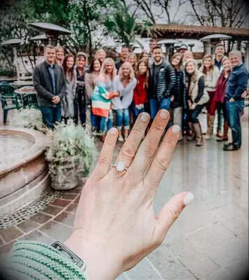 Engagement ring selfie in front of friends and family