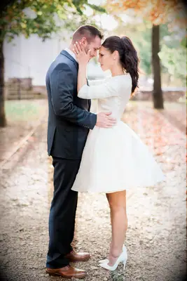 Couple in park surrounded by autumn leaves