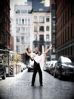 Groom lifting bride in the middle of a street