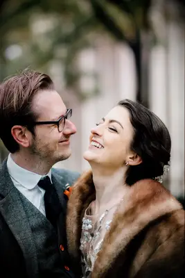 A woman and man laugh together in a close-up for their engagement photoshoot