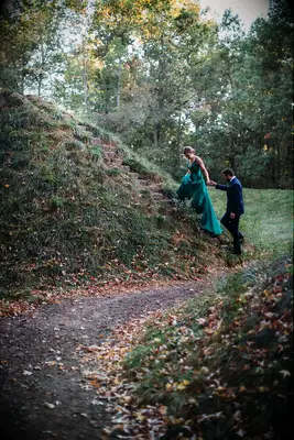 A couple climb up stone steps together for their engagement photoshoot