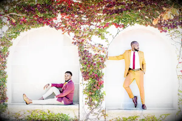 Two grooms pose among crawling autumnal vines for this stunning engagement photo