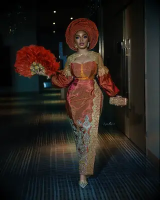 Beautiful orange traditional attire dress with feather fan