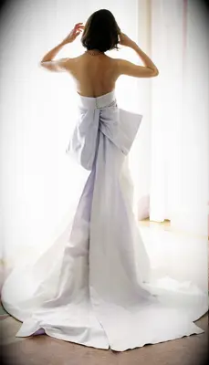 White dress with pastel purple bow by Mark Ingram Bride. 