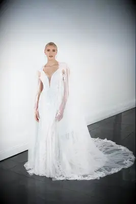 Lace fit-and-flare wedding gown with plunging neckline and matching cape