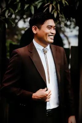 Men wearing brown bolo tie with brown suit