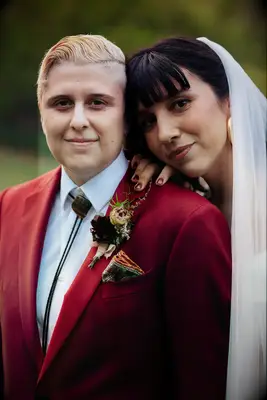 Bride wearing brown vintage bolo tie with red suit