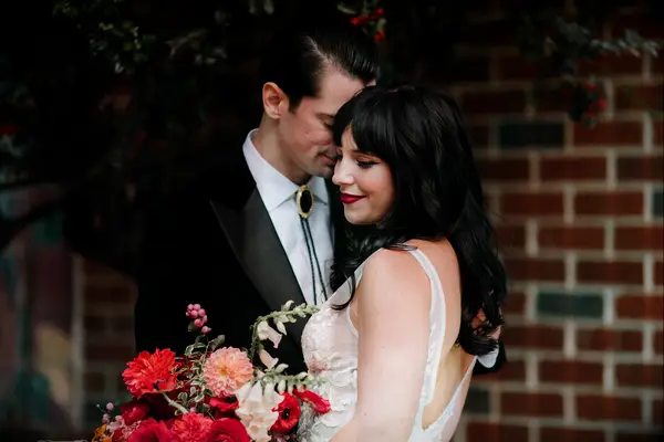 Groom wearing black and gold bolo tie with black suit