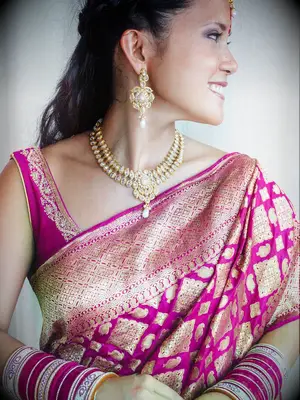 Bride wearing maroon and gold lehenga and saree