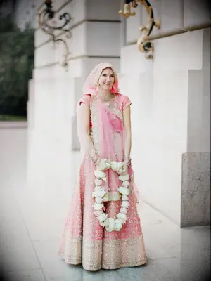 Bride wearing light pink and gold lehenga and saree