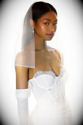 Model wears a shoulder-length sheer veil. 