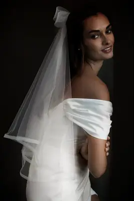 Model wears a bow-style veil with her hair pulled back. 