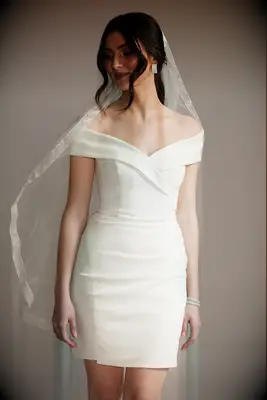 Model wears a finger-tip length veil with a beautiful hem. 