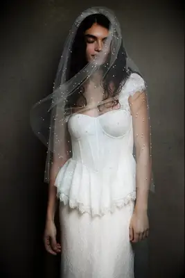 Model wears a beautiful veil embellished with pearls. 