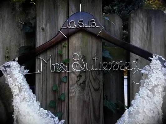 Dark wooden hanger with future last name and wedding date in silver wire