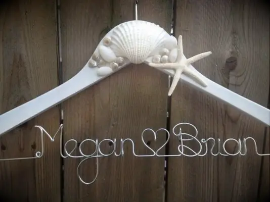 White hanger with seashells and couple