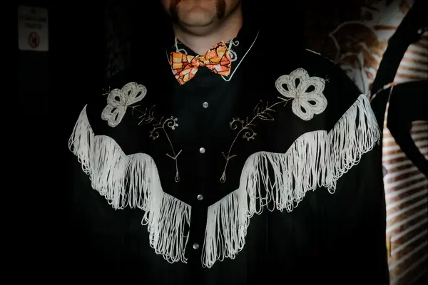 Groom in Boho Western Fringe Jacket and Orange Bow Tie