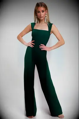 Woman wearing dark green sleeveless jumpsuit for dressy casual wedding guest attire