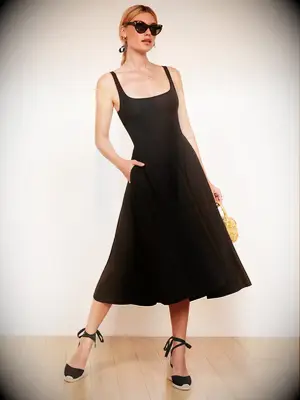 Woman wearing long black sleeveless dress for dressy casual wedding guest attire