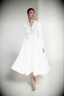 Tea-length long-sleeve wedding dress with button front and bow